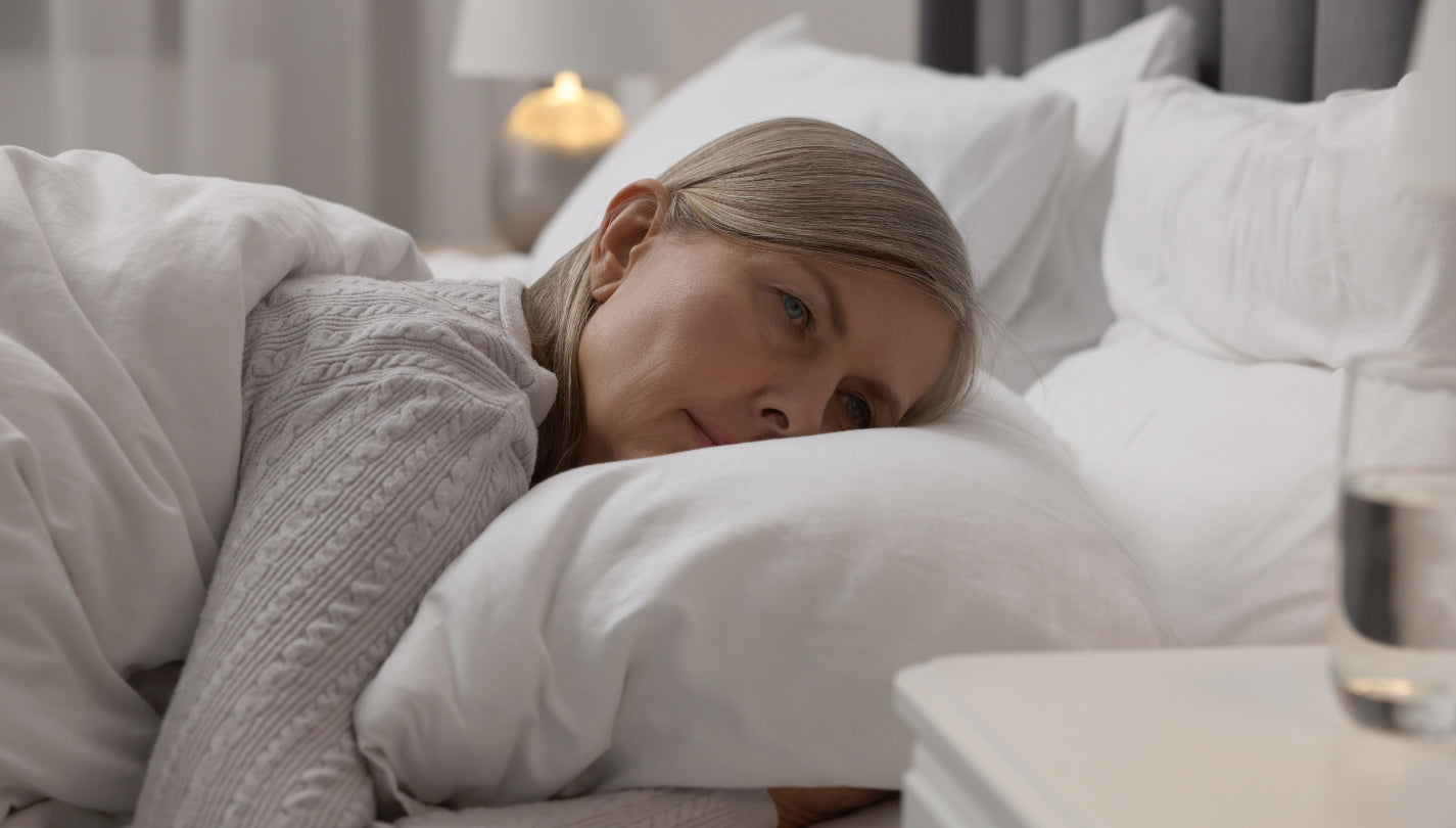 Kvinne ligger i sengen og har problemer med å sove